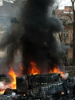 car destroyed and set on fire during the riots. city center. clouds of smoke